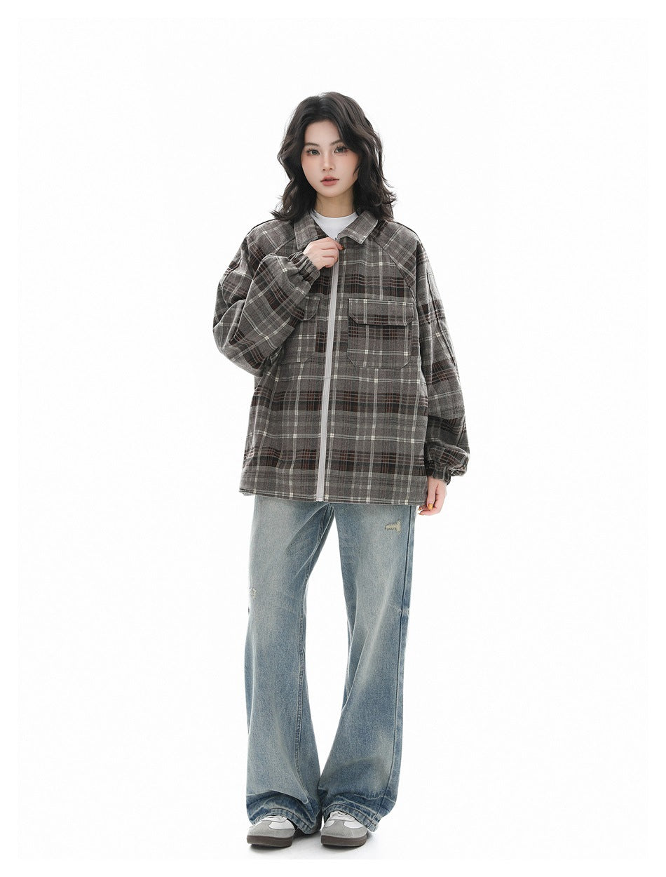 Full-length model wearing a gray plaid zip-front jacket with flap chest pockets and loose blue jeans.