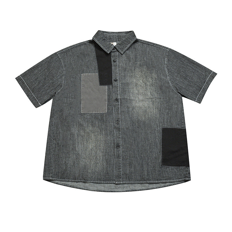 Flat lay of gray washed short-sleeve button-front shirt with black and gray patchwork panels and white topstitching