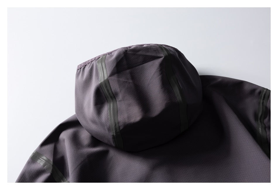 Close-up of the back hood and shoulder of a dark charcoal jacket with dark seam tape.