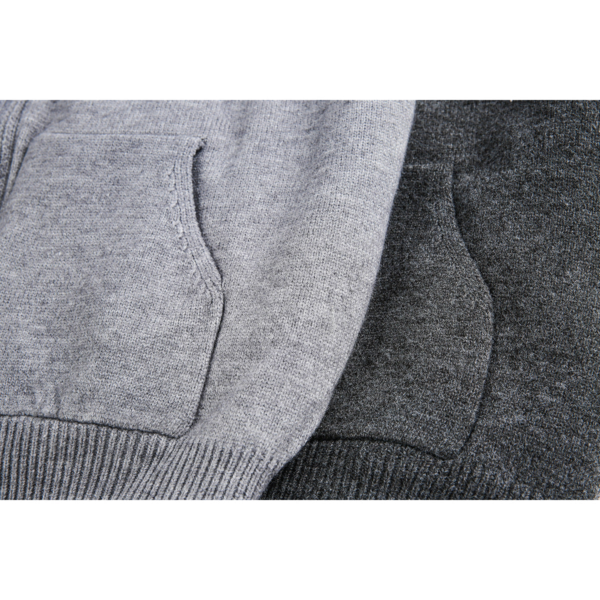 Close-up of light gray and charcoal knit hoodie fronts, showing patch pockets and ribbed lower hems.