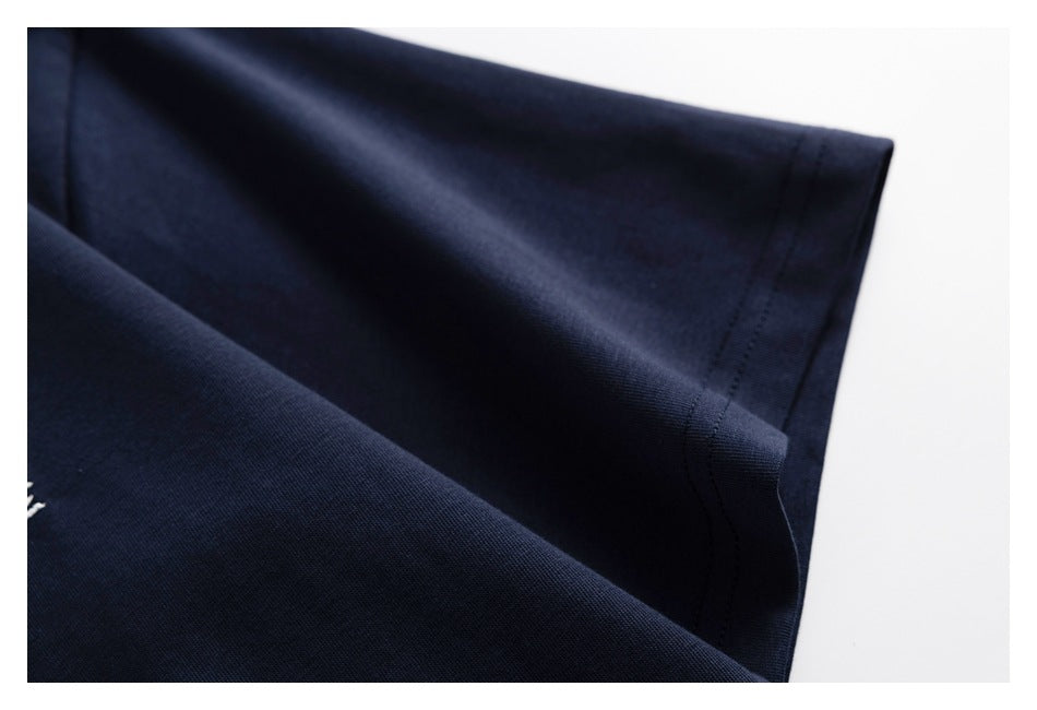 Close-up of a stitched edge on dark navy fabric against a white background.