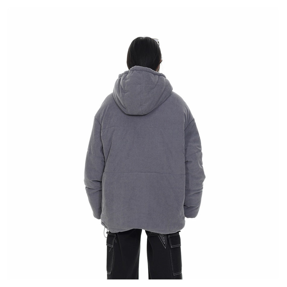 Rear view of a model wearing an oversized gray hooded jacket with paneled sleeves and a long, hip-covering cut.