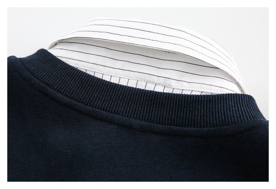 Close-up of a dark navy sweatshirt's ribbed crew neckline with white pinstriped fabric visible inside.