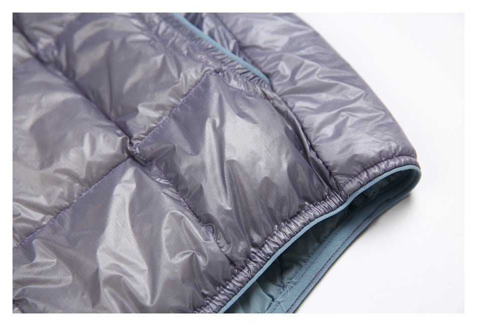 Close-up of a gray quilted jacket hem with pale blue edging and blue lining.