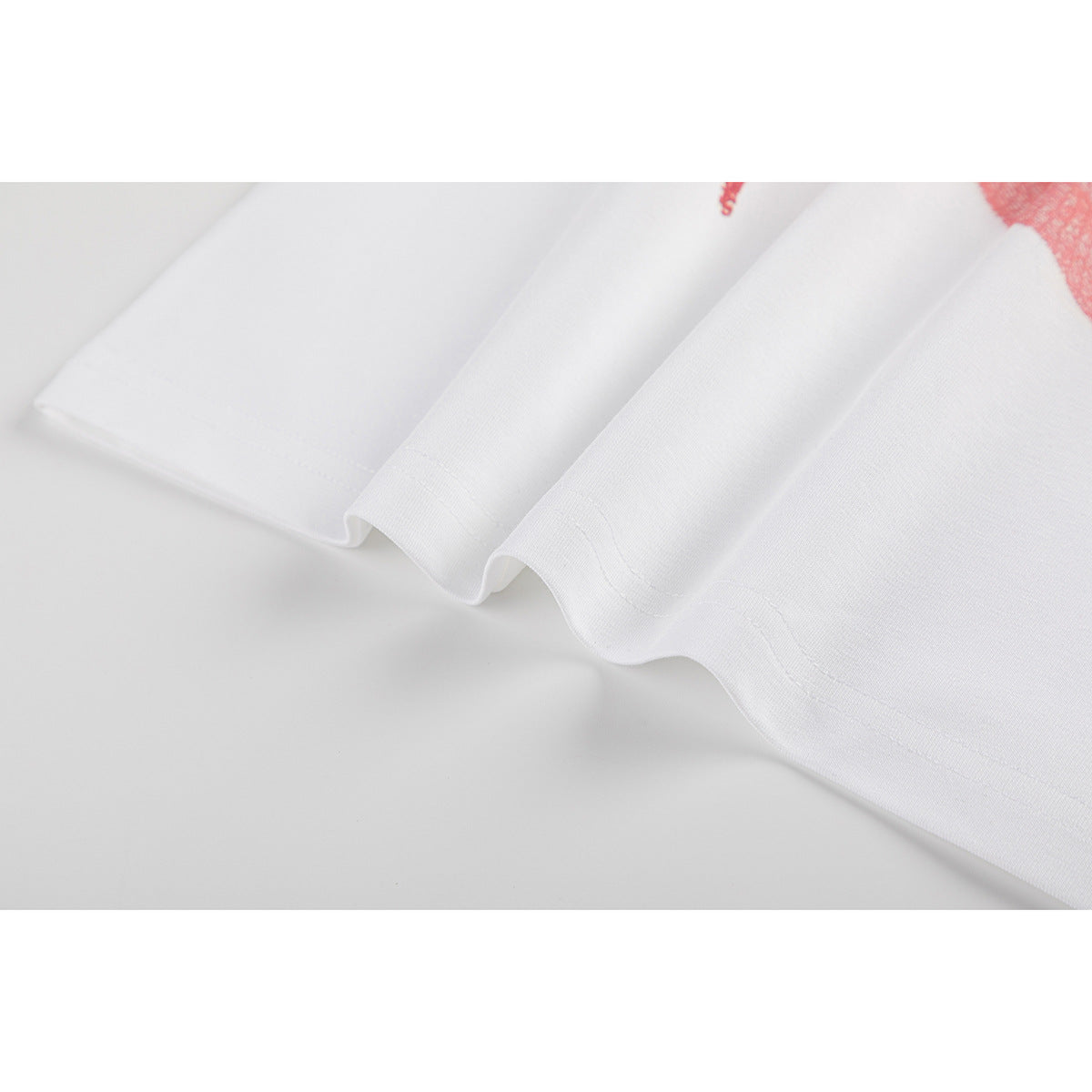 Close-up of the white T-shirt's folded, stitched hem.