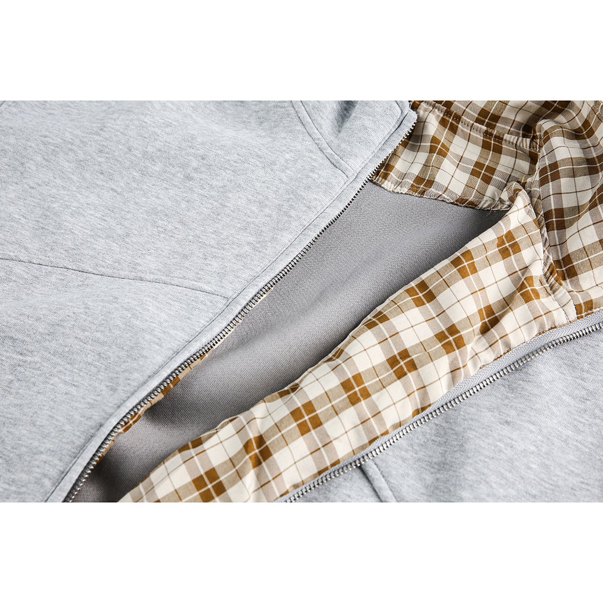 Close-up of the open light gray jacket showing brown plaid lining and the front zipper.