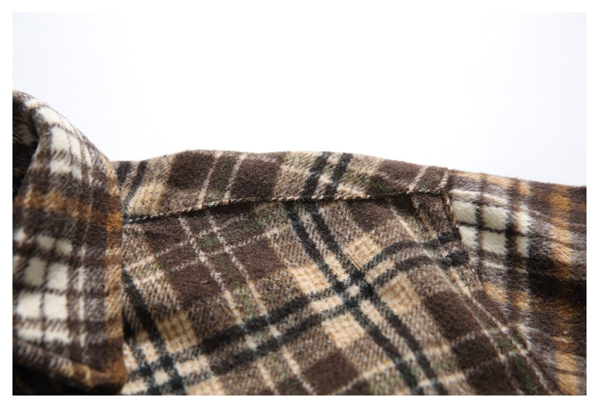 Close-up of the brown plaid shirt's folded collar edge and stitched seam.