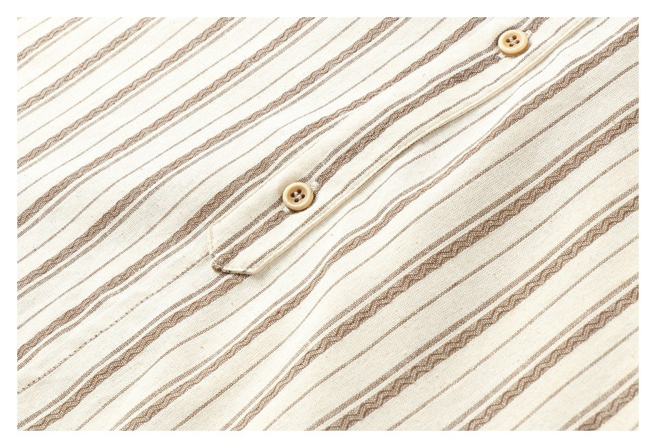 Close-up of two tan buttons on a placket against cream fabric with brown stripes.