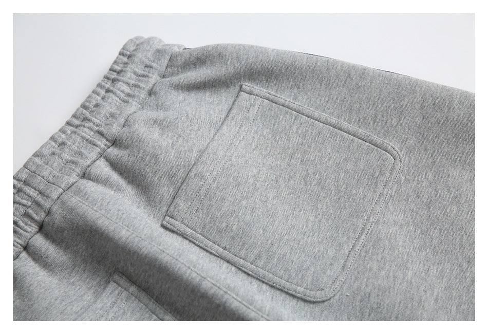 Close-up of gray sweatpants with a stitched square back pocket and elastic waistband.