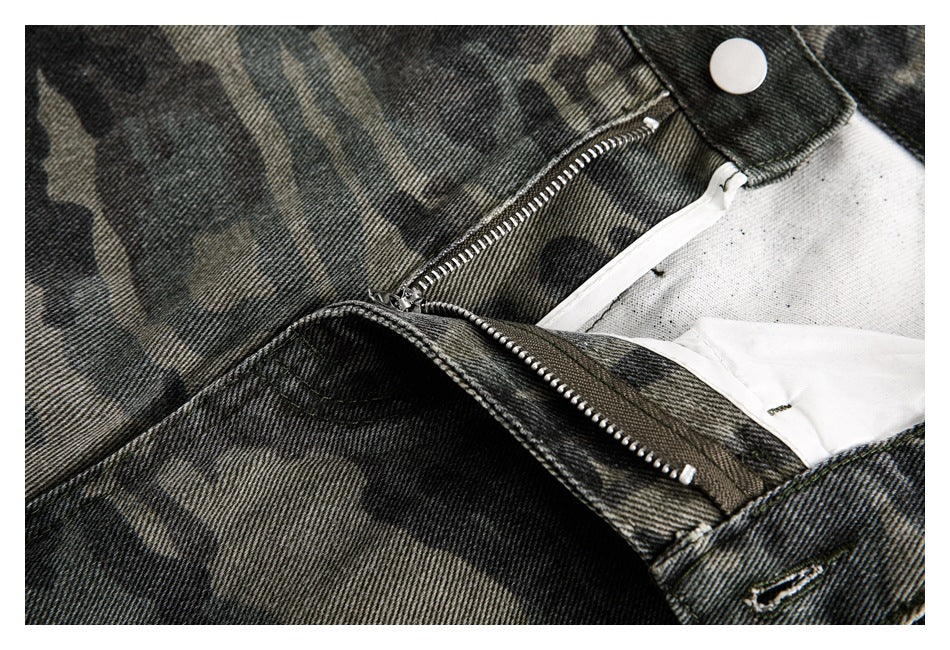 Close-up of the open zipper fly and button fastening on dark camouflage pants.