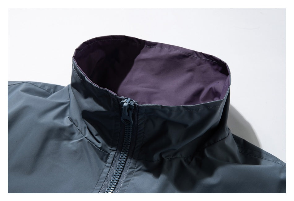 Close-up of a slate-blue jacket’s raised collar with purple lining and a front zipper.
