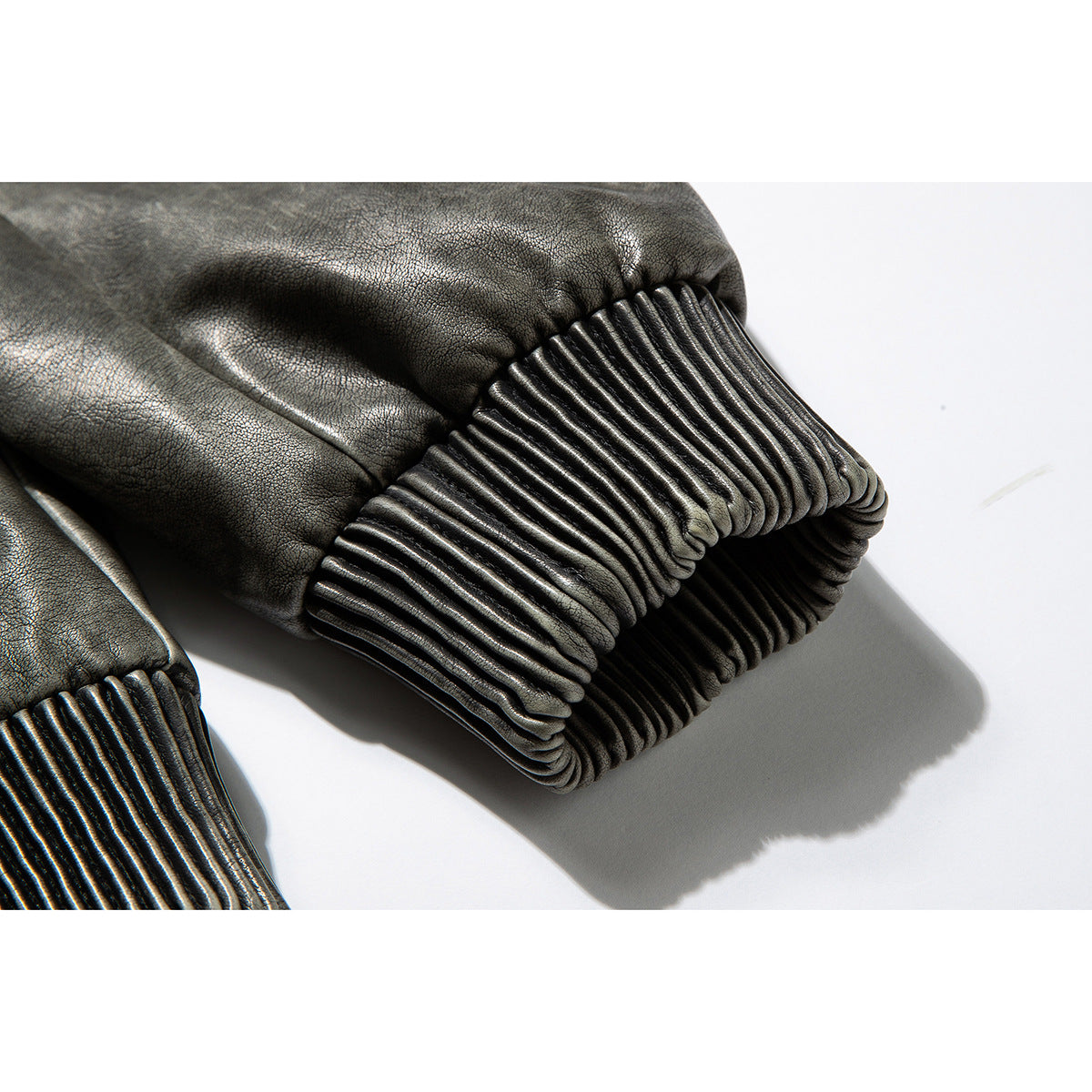 Close-up of a charcoal-gray jacket sleeve ending in a wide ribbed cuff.
