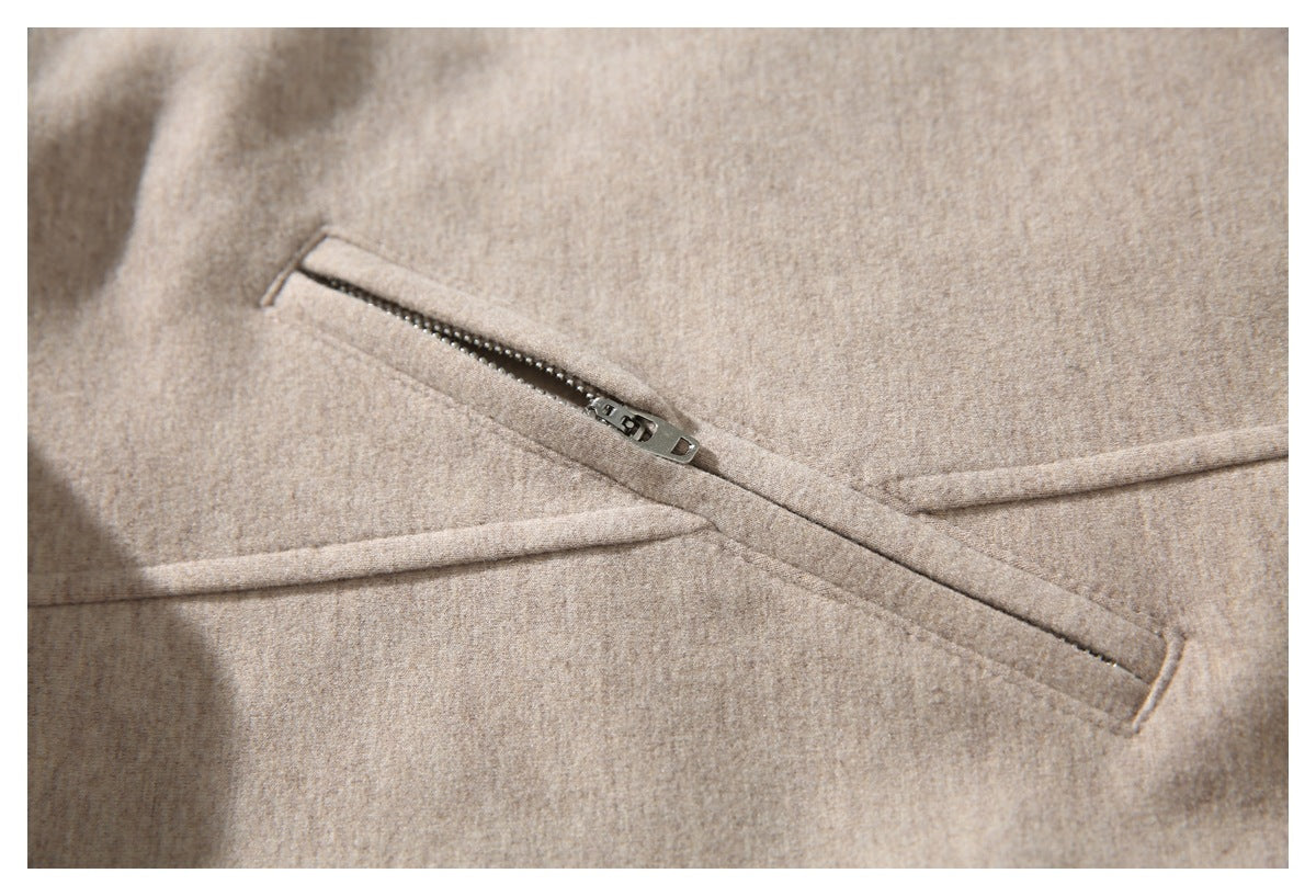 Close-up of a slanted zip pocket on beige coat fabric.