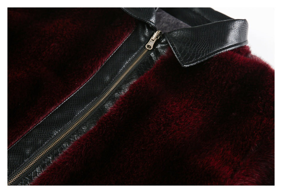 Close-up of the jacket’s black textured zipper trim and collar on burgundy plush fabric.