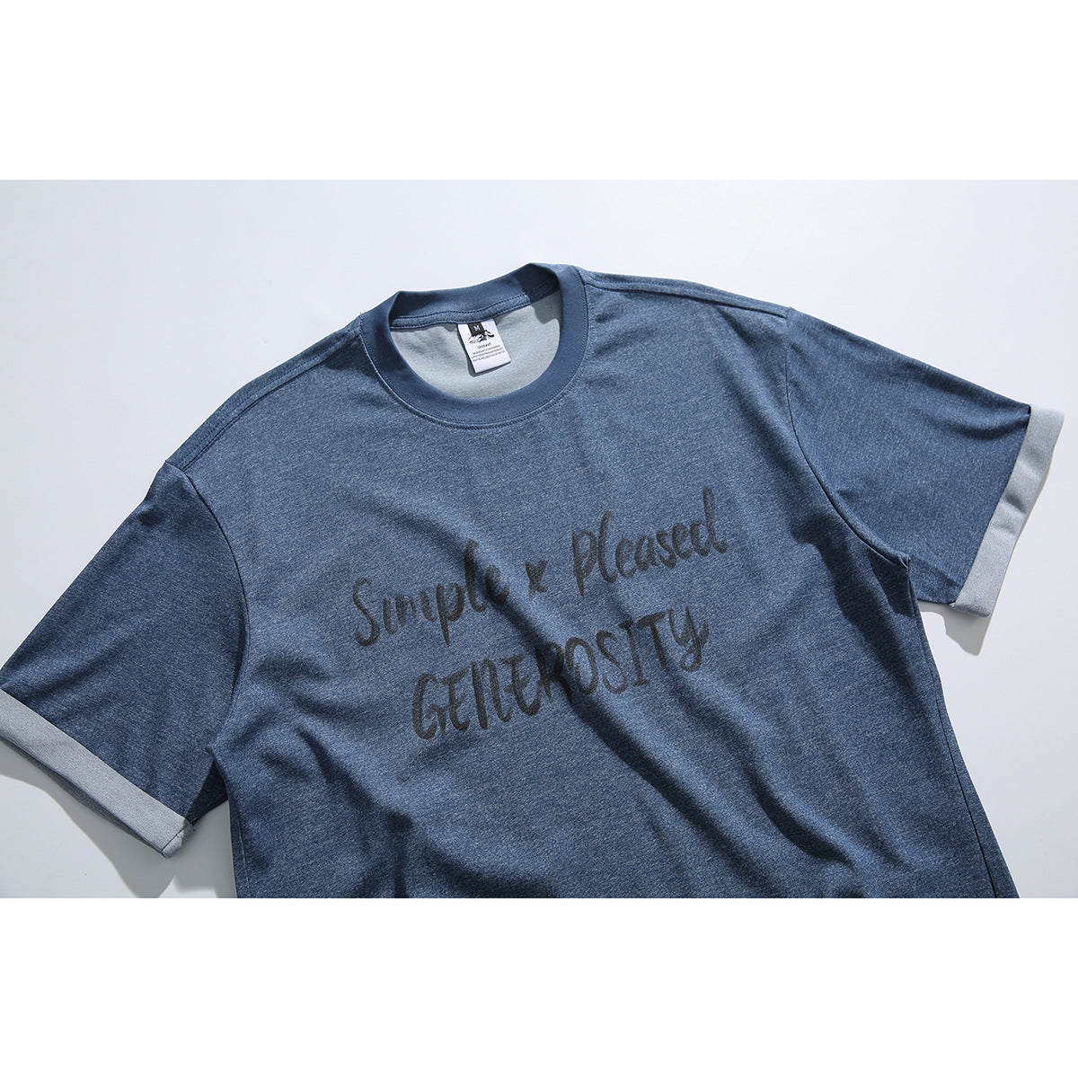 Angled close view of a blue short-sleeve T-shirt with light sleeve cuffs and dark English lettering across the chest.