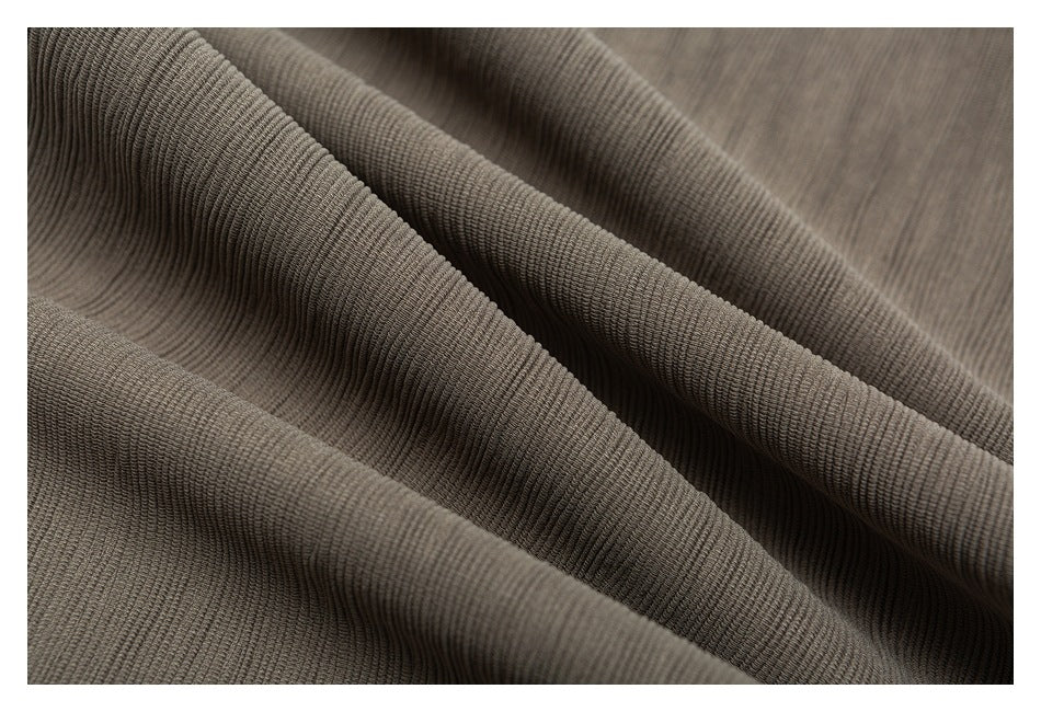 Close-up of taupe-gray fabric arranged in soft folds, showing a fine ribbed texture.