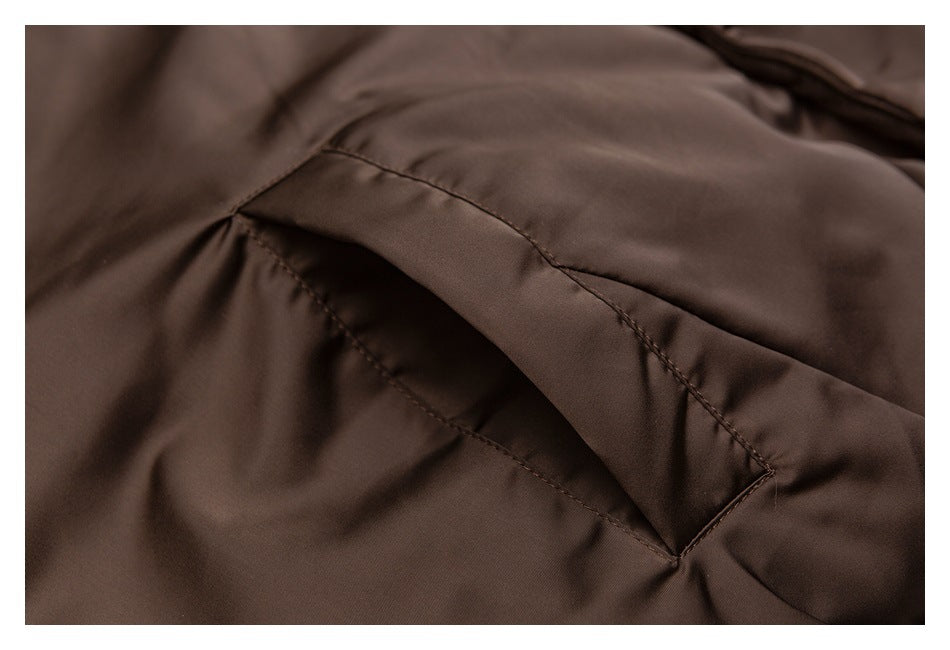 Close-up showing the angled welt pocket opening on a dark brown jacket.