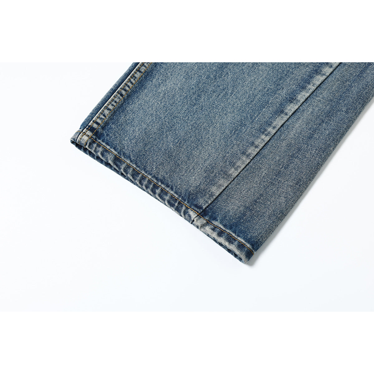 Close-up of the double-stitched hem on a blue denim jeans leg.