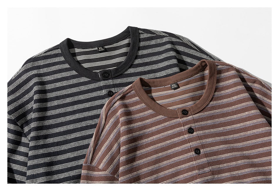 Two striped knit shirts laid together: one black with light stripes and one brown with cream and pale blue stripes.