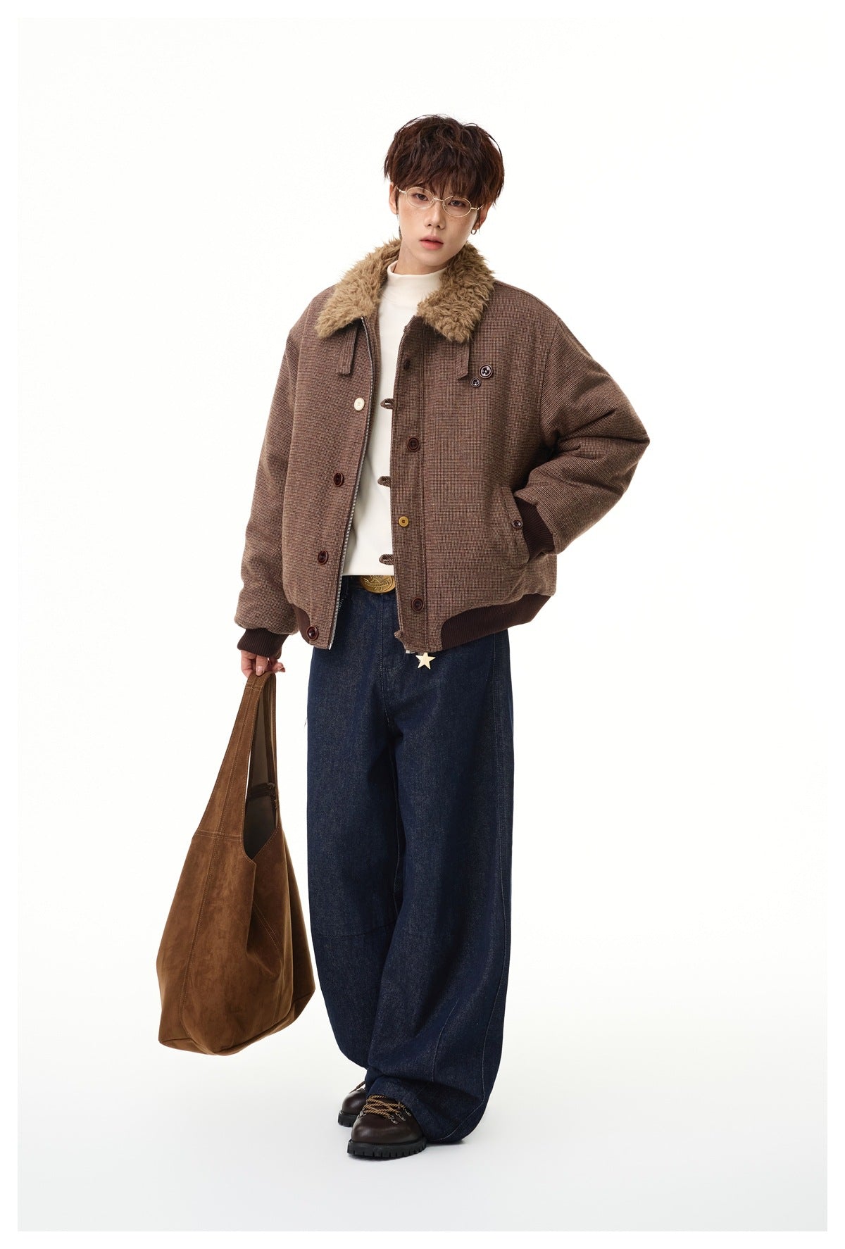 Model wearing a brown bomber jacket with fleece-like collar, cream top, wide dark jeans and a brown tote bag