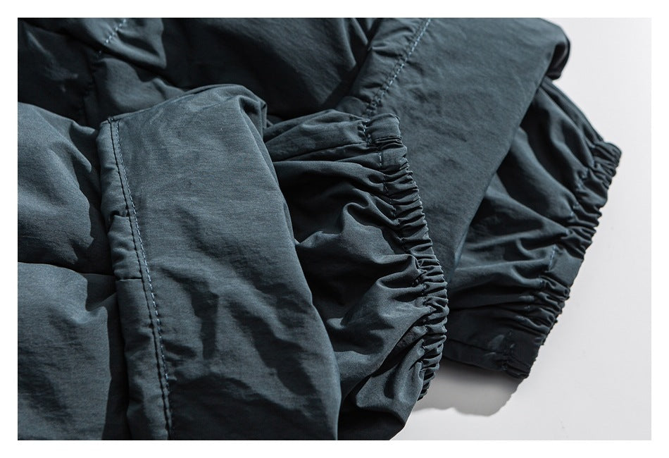 Close-up of dark garment construction with stitched panels and gathered elastic sections.