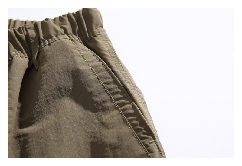 Close-up of a gathered elastic waistband and stitched seam on an olive-brown garment.