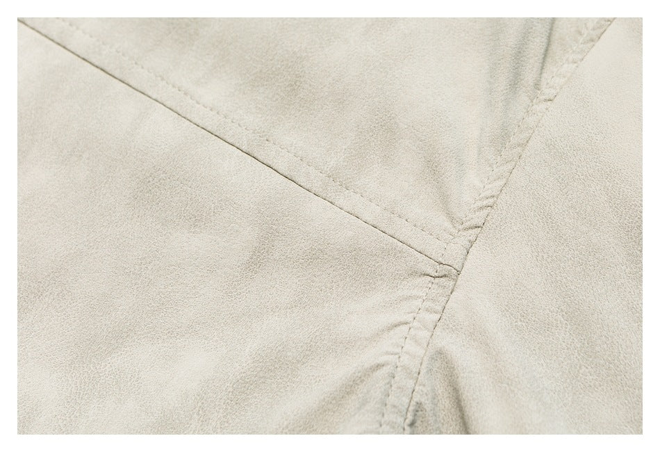 Close-up of stitching and a seam on the mottled beige shirt fabric.
