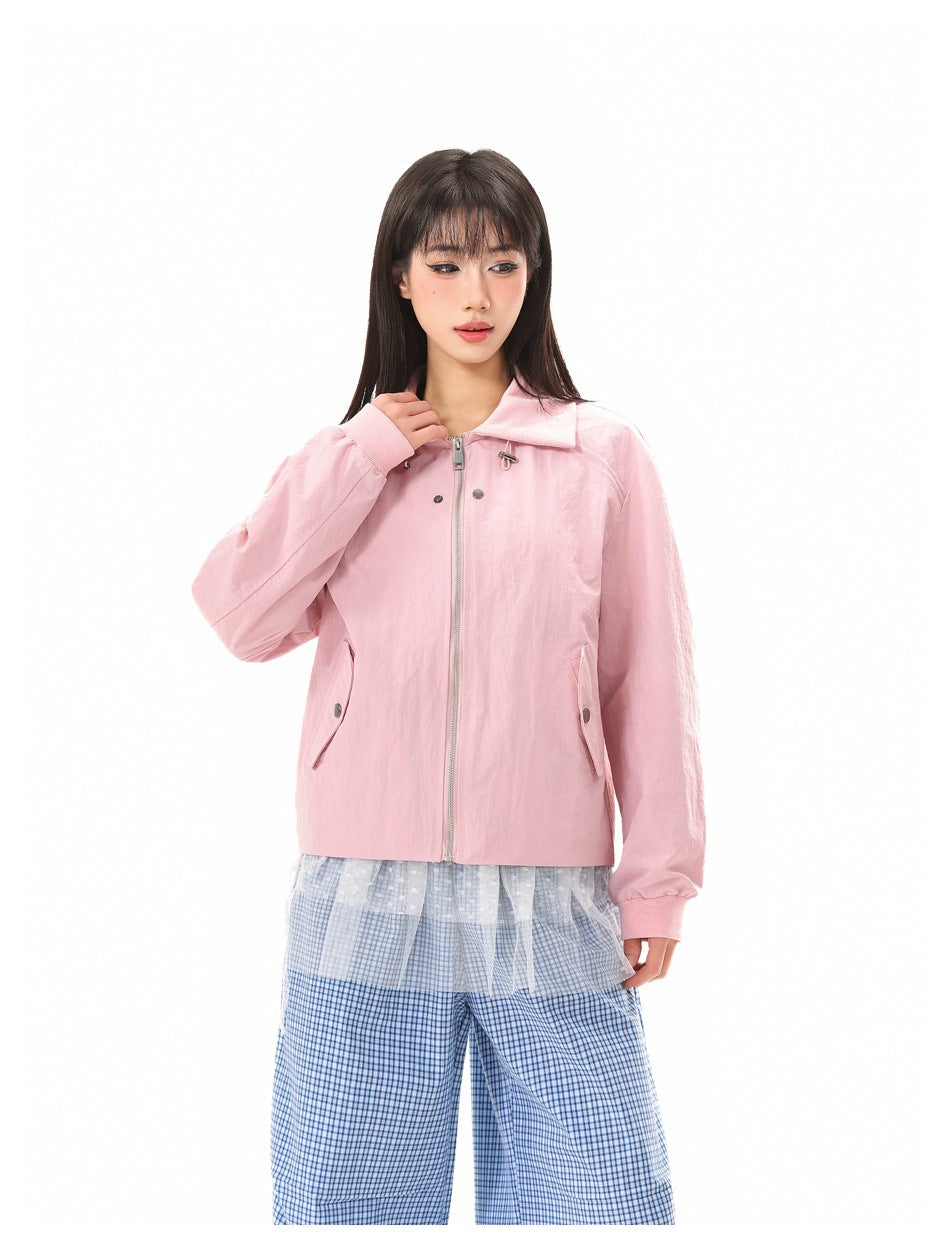 Model wearing a light pink collared jacket with a front zipper, long sleeves, and buttoned flap pockets.