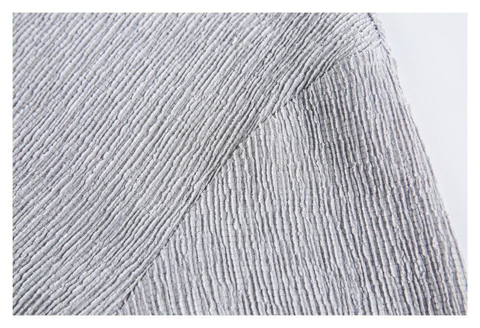 Close-up of the light gray shirt's textured sleeve and curved underarm seam.