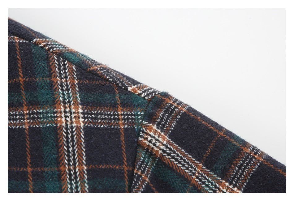 Close-up of the shoulder seam on a dark plaid garment in navy, green, rust, and white.