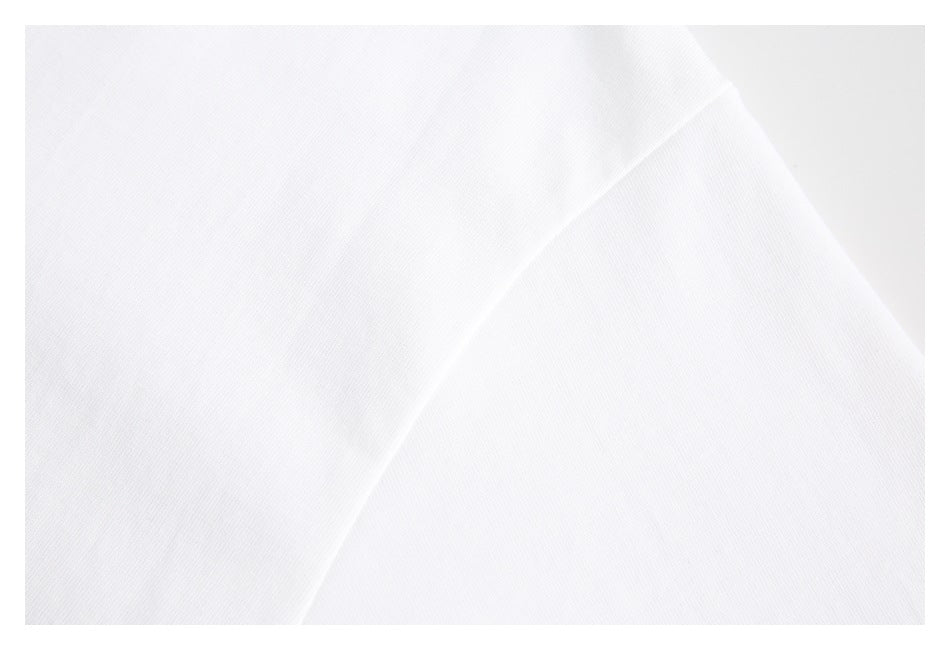 Close-up of plain white T-shirt fabric and a curved seam.
