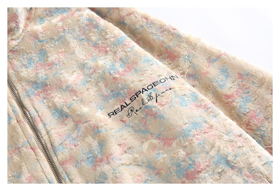 Close-up of black lettering on the jacket's raised cream, pink, and blue patterned fabric.