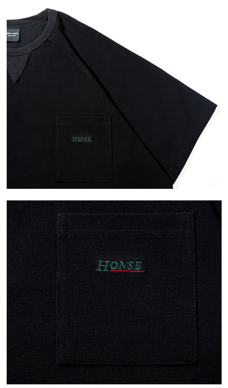 Close-up of a black T-shirt’s short sleeve and chest pocket with green embroidered lettering; lower panel magnifies the