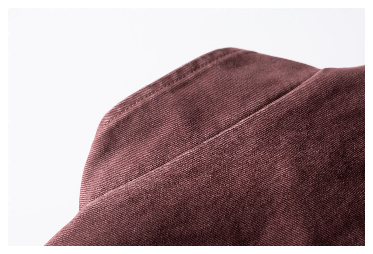 Close-up of a folded burgundy garment edge with visible stitching and diagonal fabric texture.