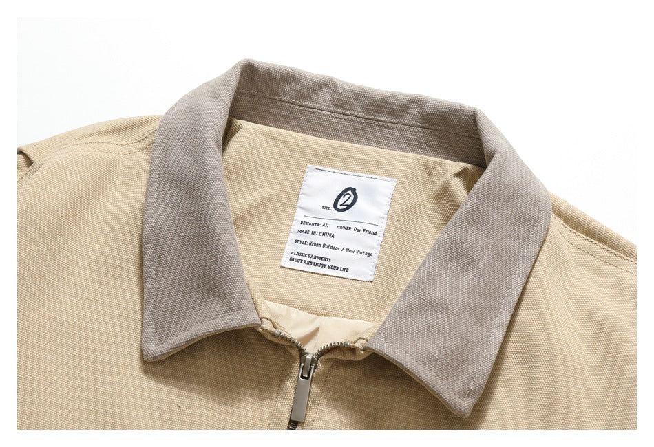 Close-up of the beige jacket's taupe collar, zipper, and sewn neck label.