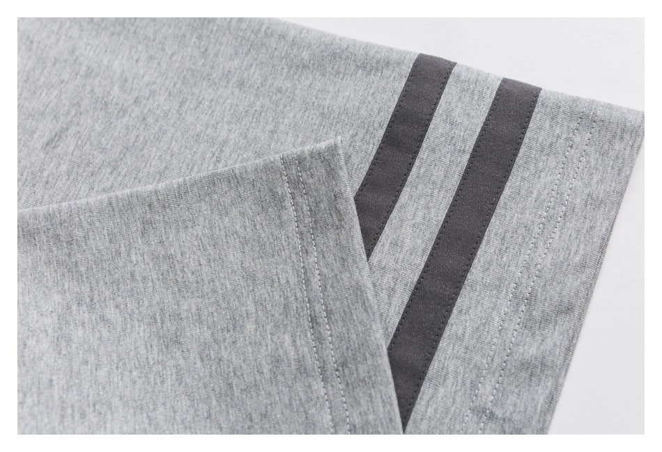 Close-up of a heather-gray T-shirt sleeve with two dark stripes and stitched seams.