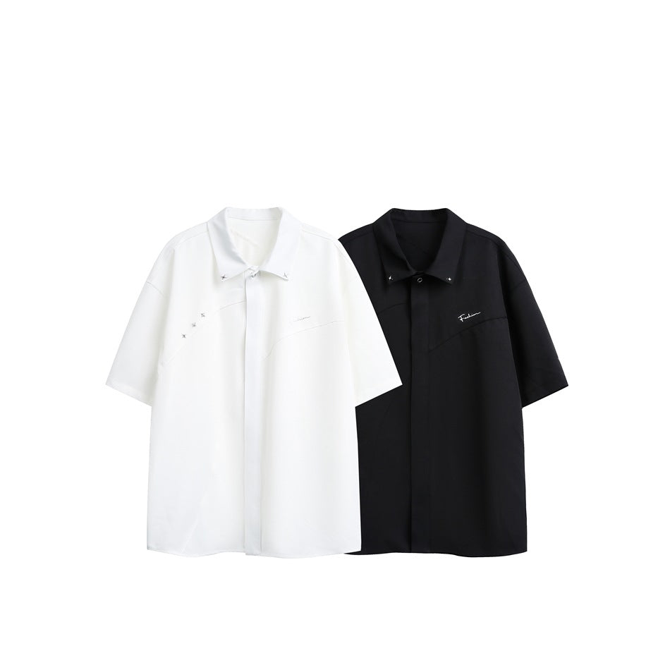 White and black short-sleeve button-up shirts displayed side by side, each with silver accents.