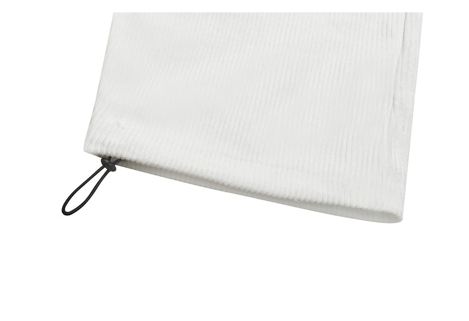 Close-up of white ribbed garment hem with a black elastic loop.