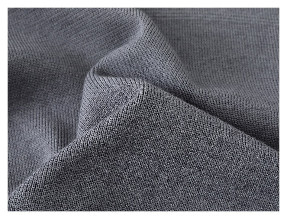 Close-up of the gray sweater's knit texture draped into soft folds.