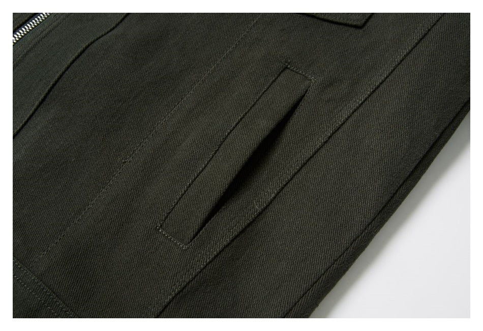 Close-up of dark olive jacket fabric and stitching around a narrow vertical pocket opening.