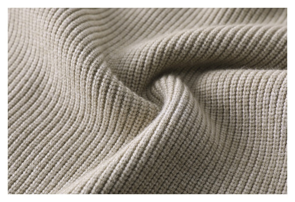 Close-up of light beige ribbed knit fabric with raised, folded texture.