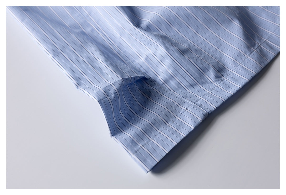 Close-up of the light blue striped shorts' stitched hem and draped fabric.