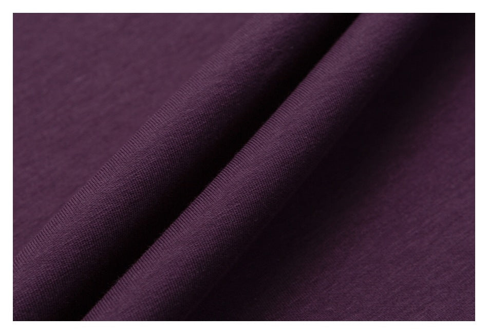 Extreme close-up showing the plum shirt fabric draped into soft folds.