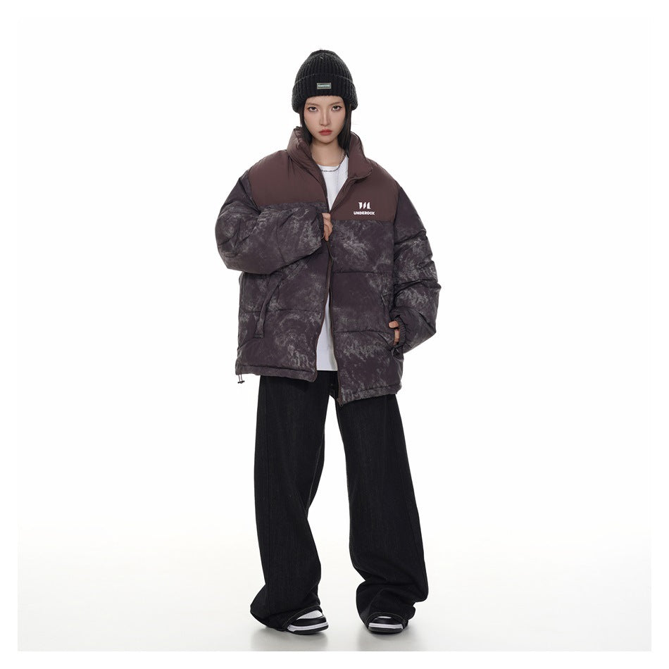 Full-length model wearing the plum and charcoal mottled puffer jacket open over a white top.