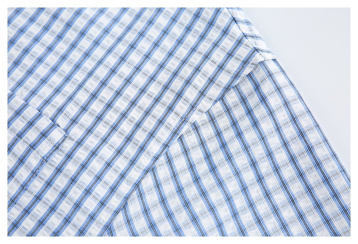 Close-up of blue, white, and dark striped plaid shirt fabric with a curved stitched seam.