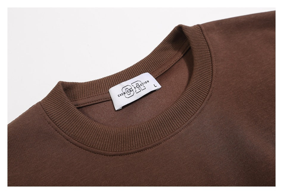 Close-up of a brown crewneck garment with a ribbed collar and a visible size L neck label.