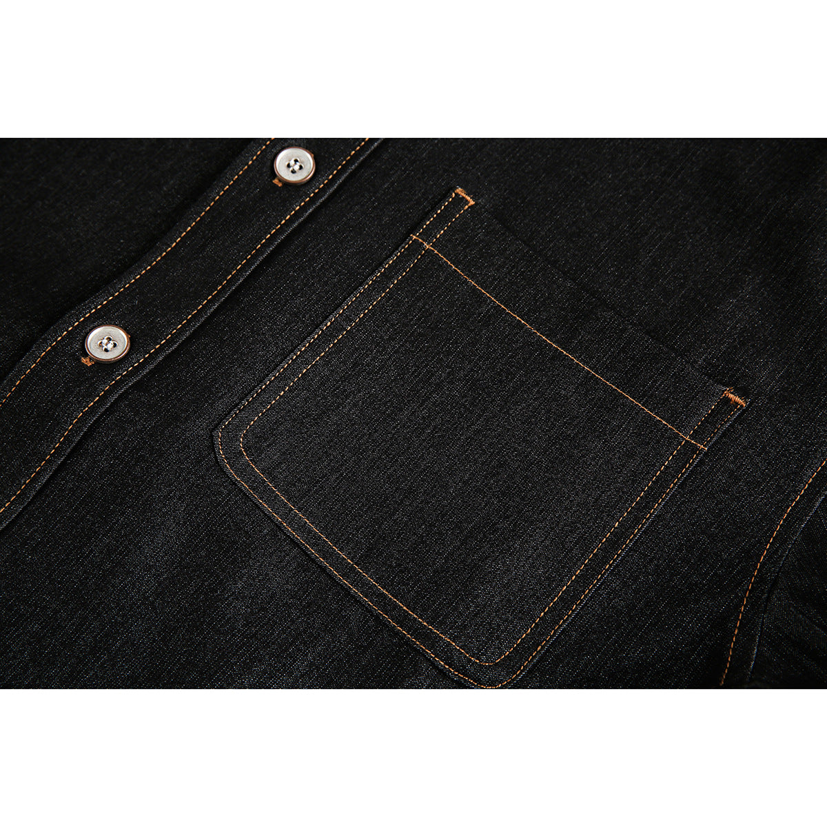 Close-up of a dark denim shirt's chest pocket and button placket, finished with orange contrast stitching.
