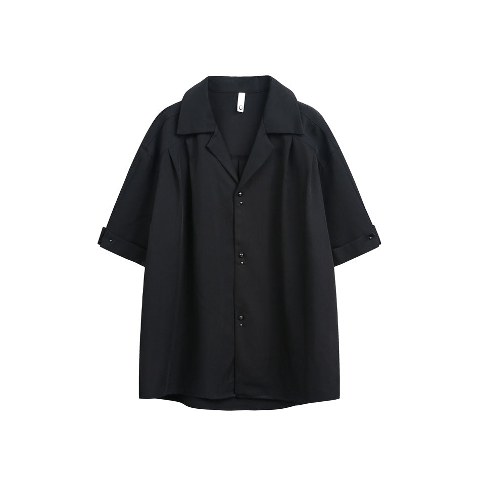 Black short-sleeve shirt flat lay with notched collar, stud buttons and turned-up studded cuffs