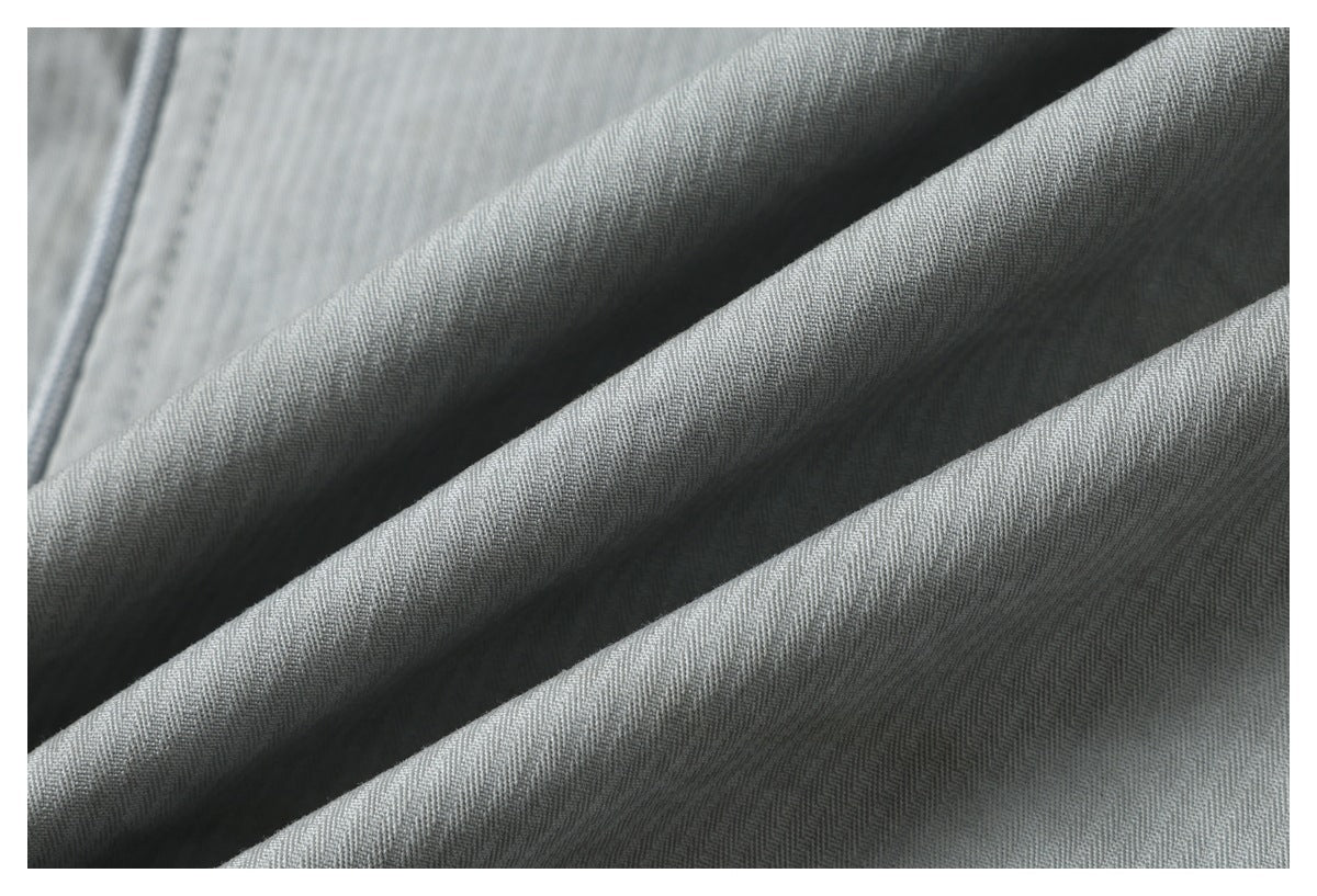 Macro view of the subtle diagonal weave and folds in gray fabric.