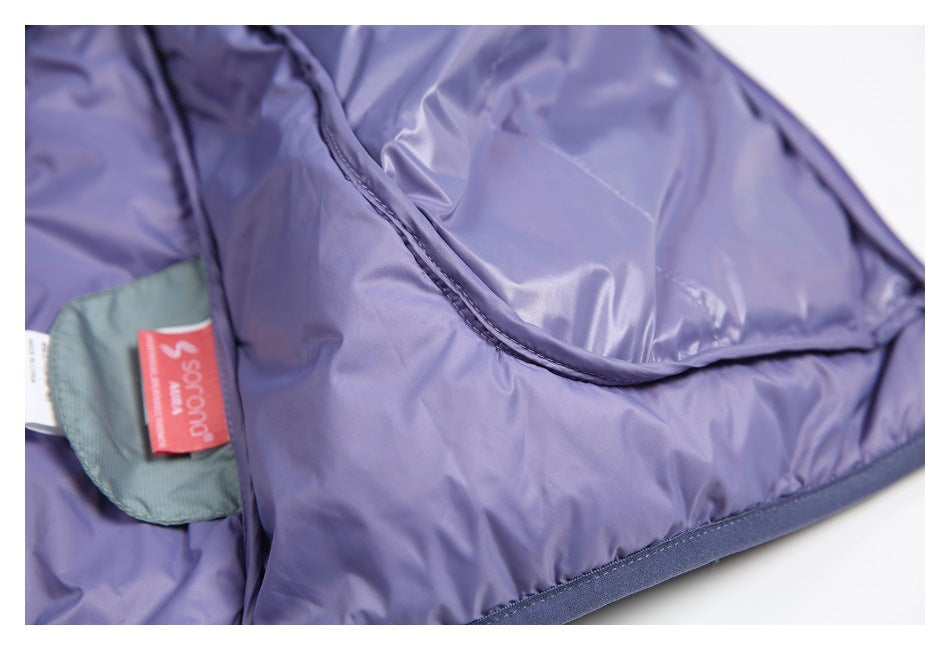 Close-up of lavender padded garment lining with a curved stitched seam and a red sewn-in label.